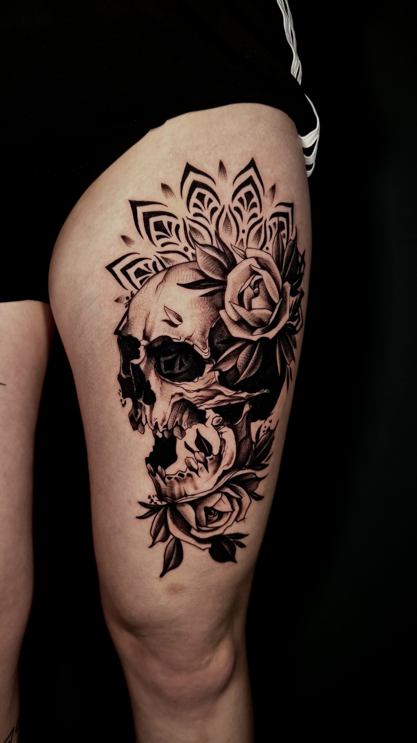 Schädel- und Rosentattoo auf Oberschenkel