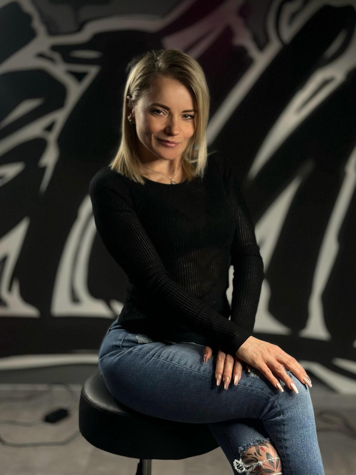 Frau auf Hocker vor grauem Hintergrund