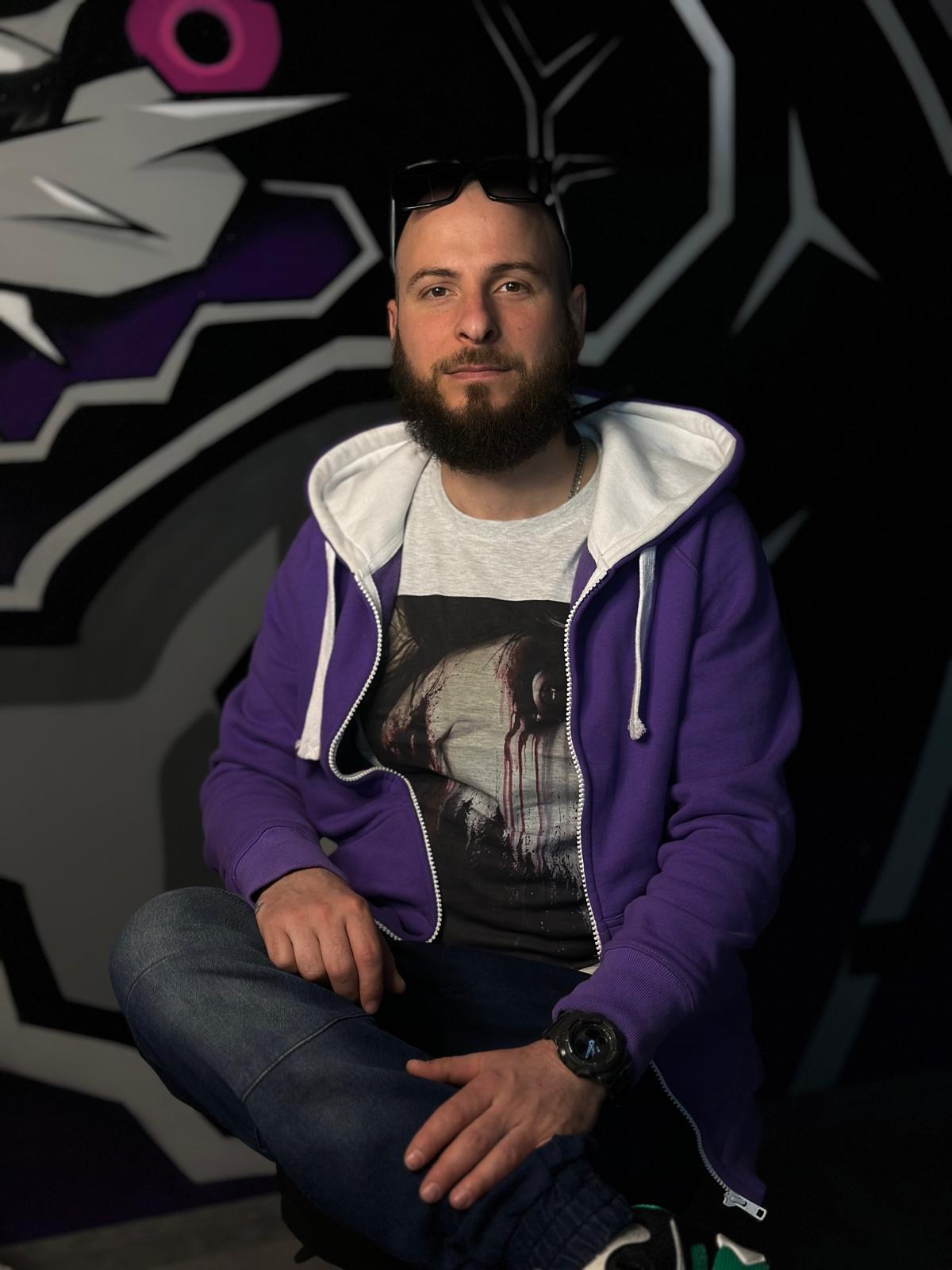 Mann mit Bart vor grafischem Hintergrund.