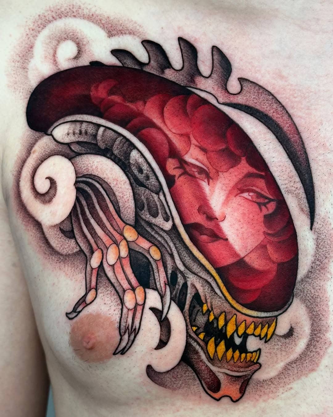 Abstrakte Tätowierung auf Brust, rot-schwarze Farben.