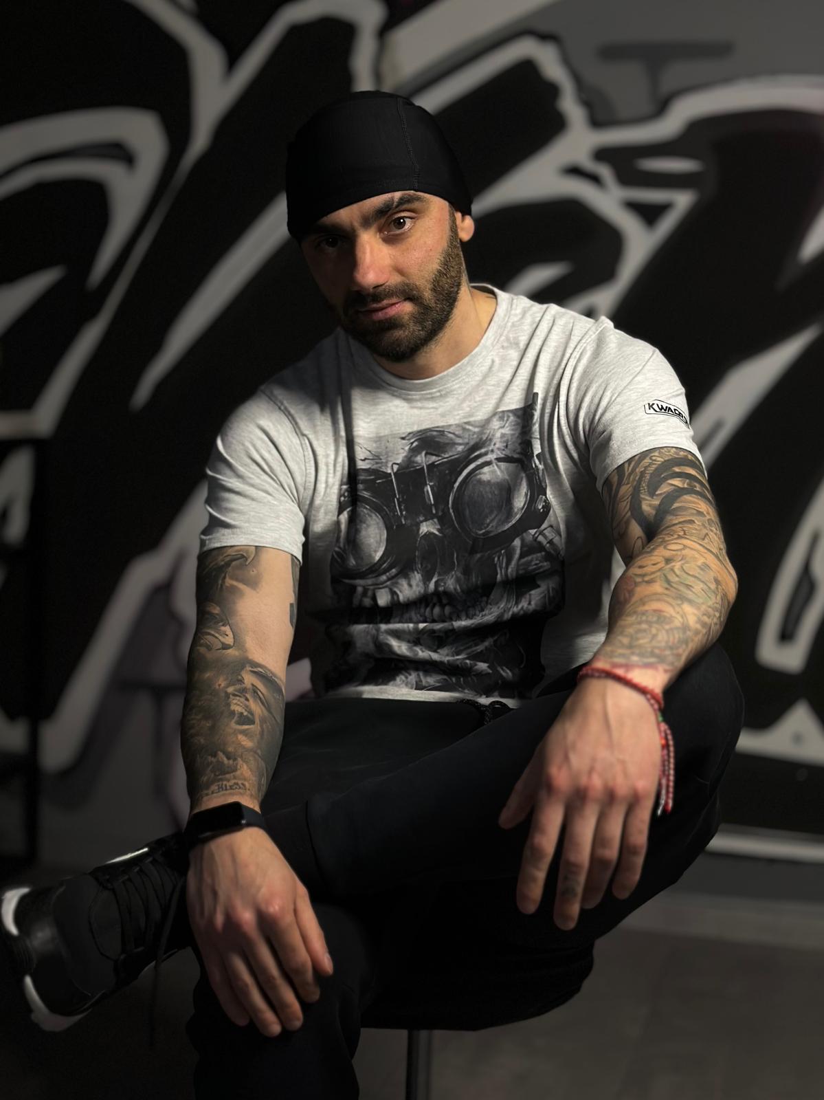 Mann im Fitnessstudio vor Graffiti-Wand sitzend.