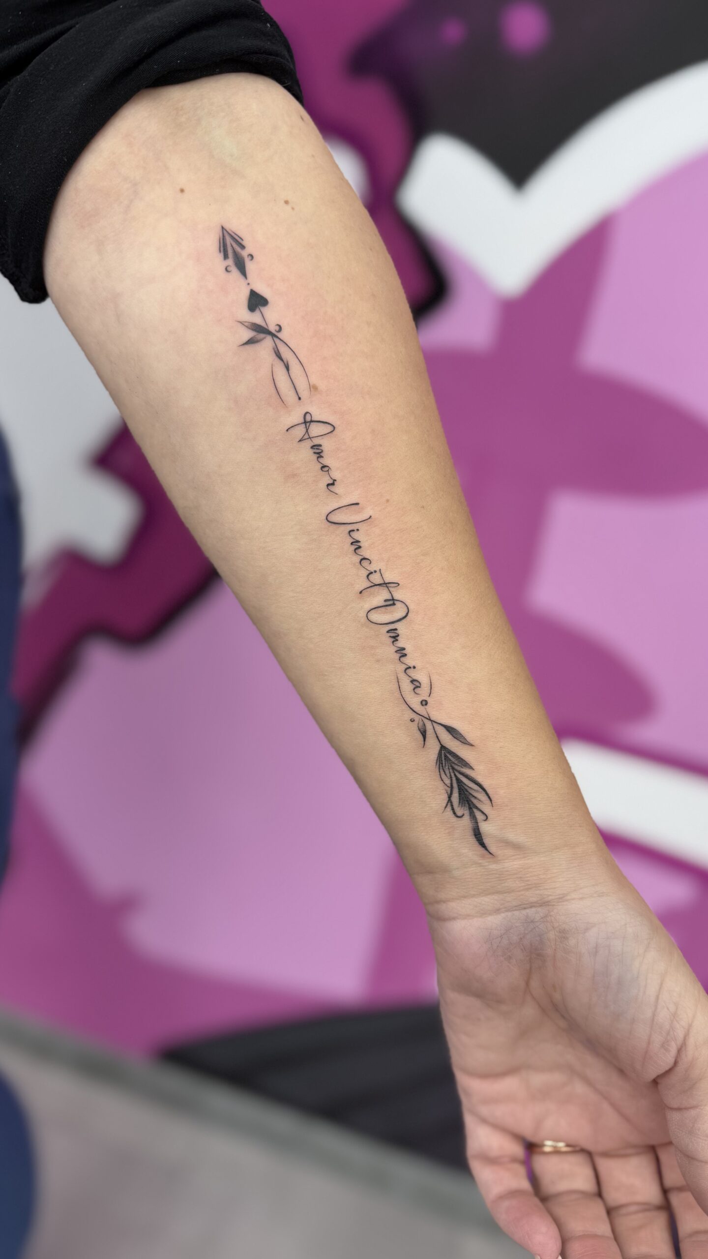 Tätowierung mit Pfeil und Script auf dem Unterarm