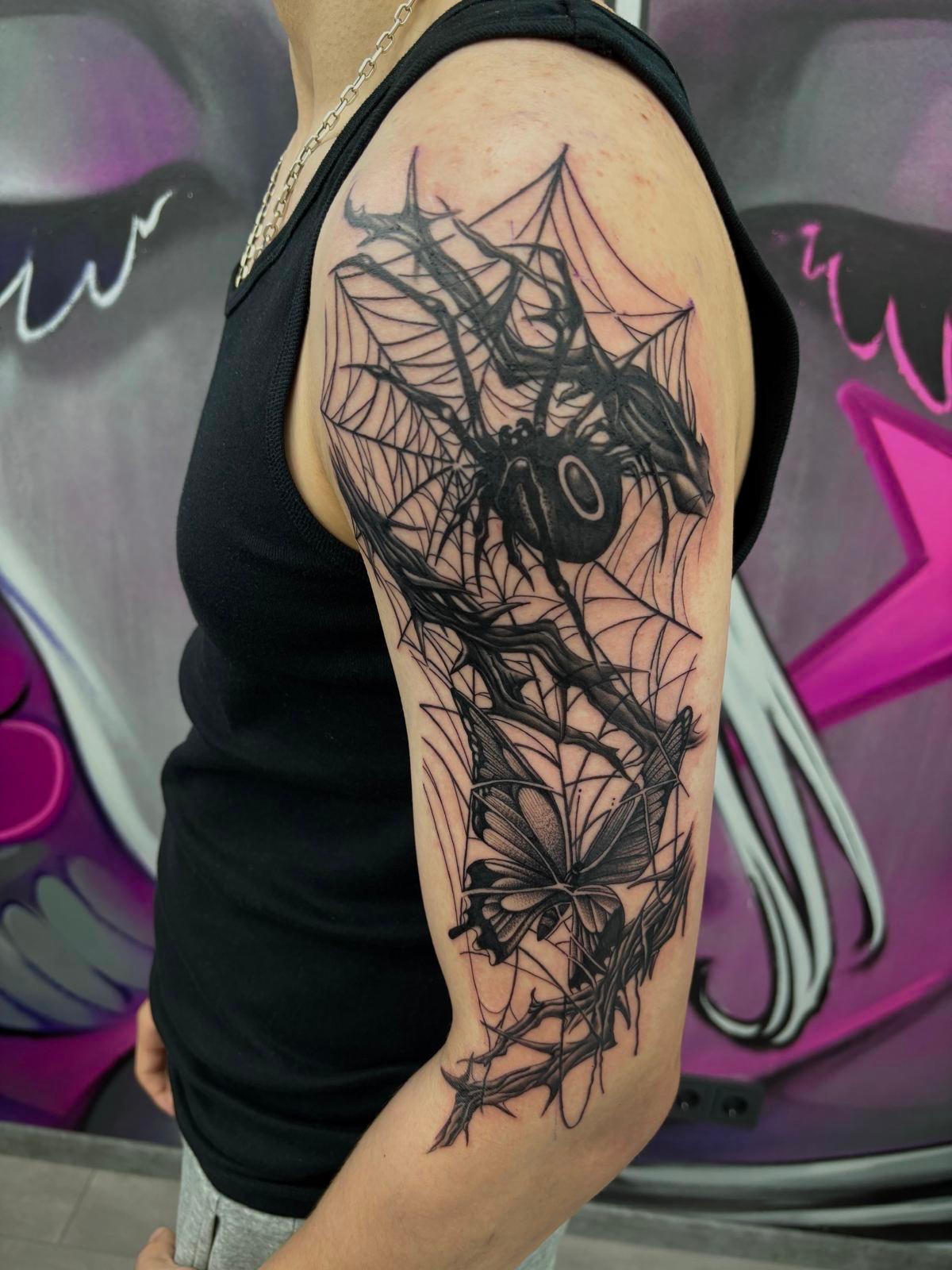 Tattoo von Spinne und Schmetterling auf Oberarm