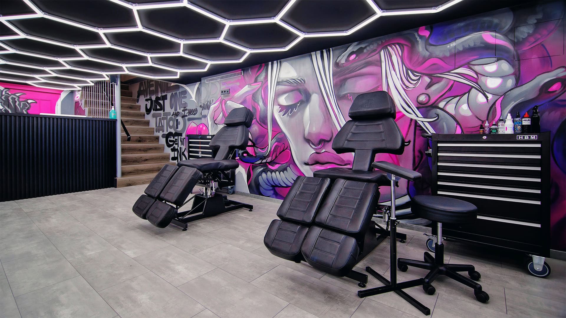 Modernes Tattoo-Studio mit Graffiti-Wand und Behandlungsstühlen.