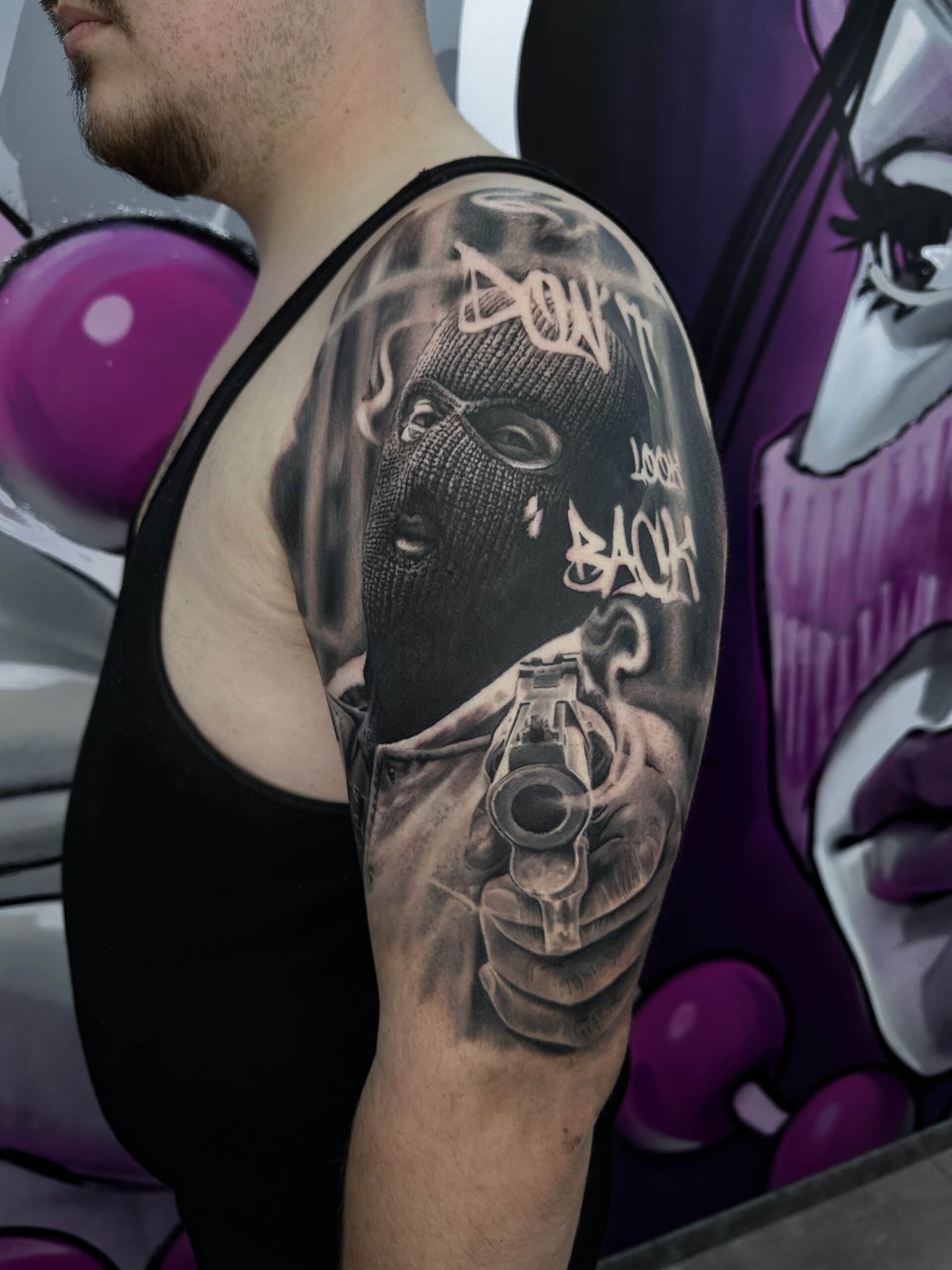 Oberarmtattoo "Chicano" mit Maske und Schriftzug "Don't Look Back".