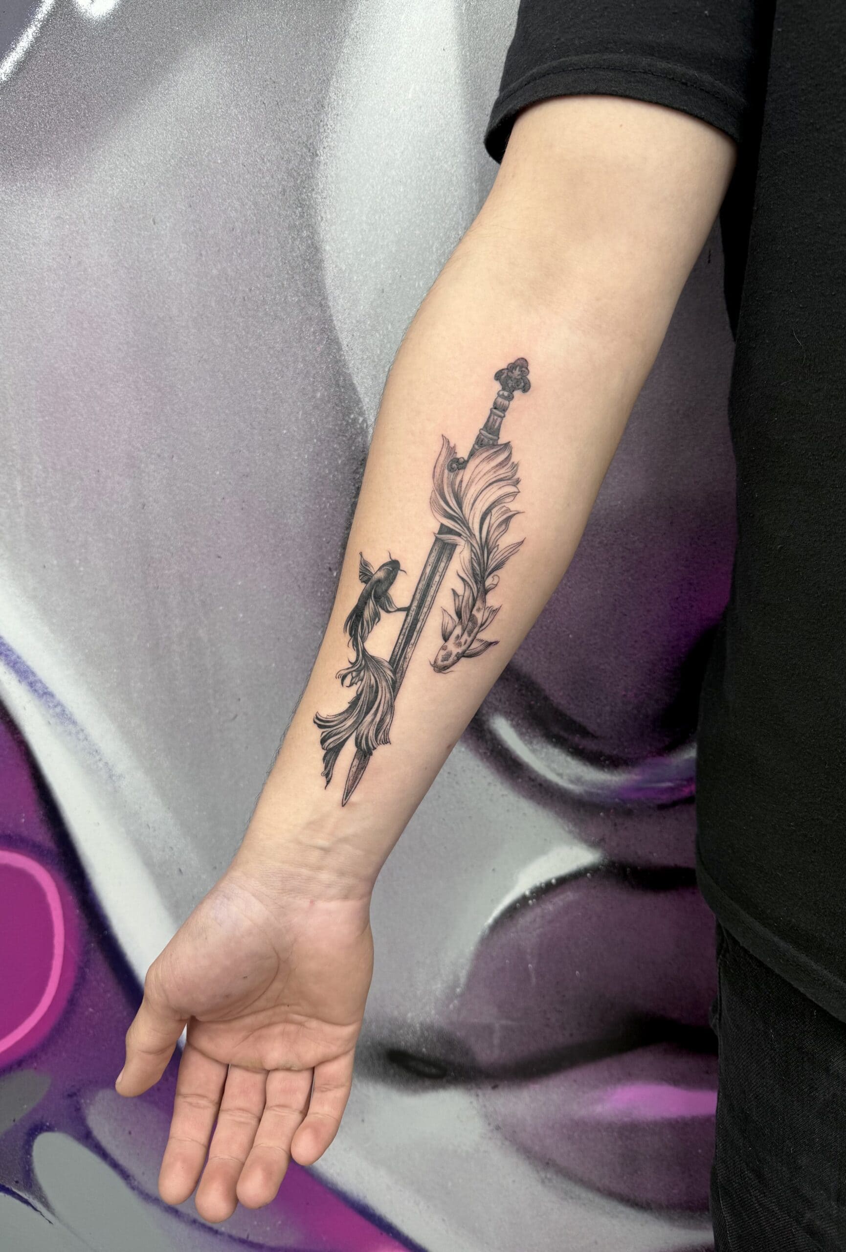 Yin und Yang Fische Tattoo mit Schwert am Unterarm